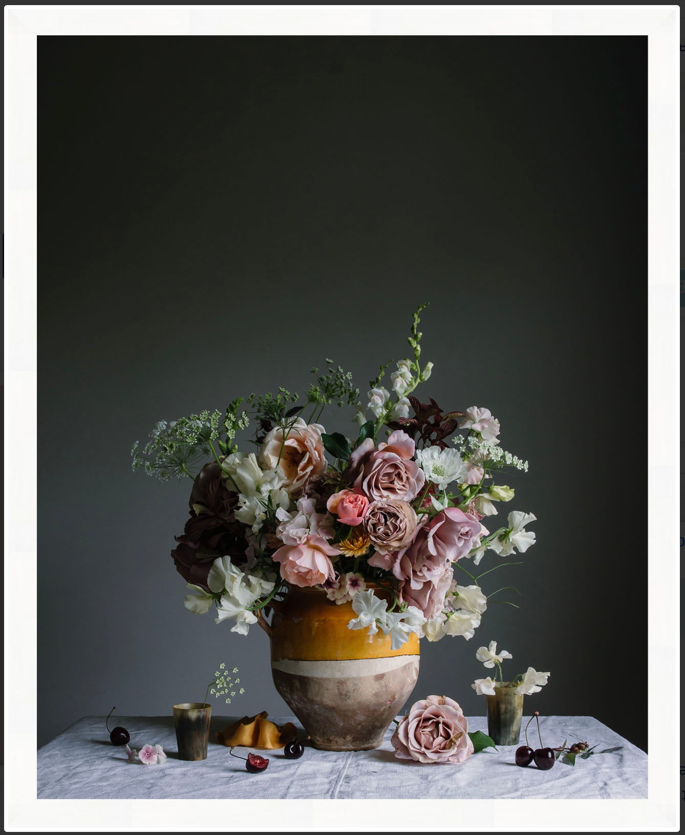 Floral arrangement in a vase on a table with a dark background. Floral artwork
