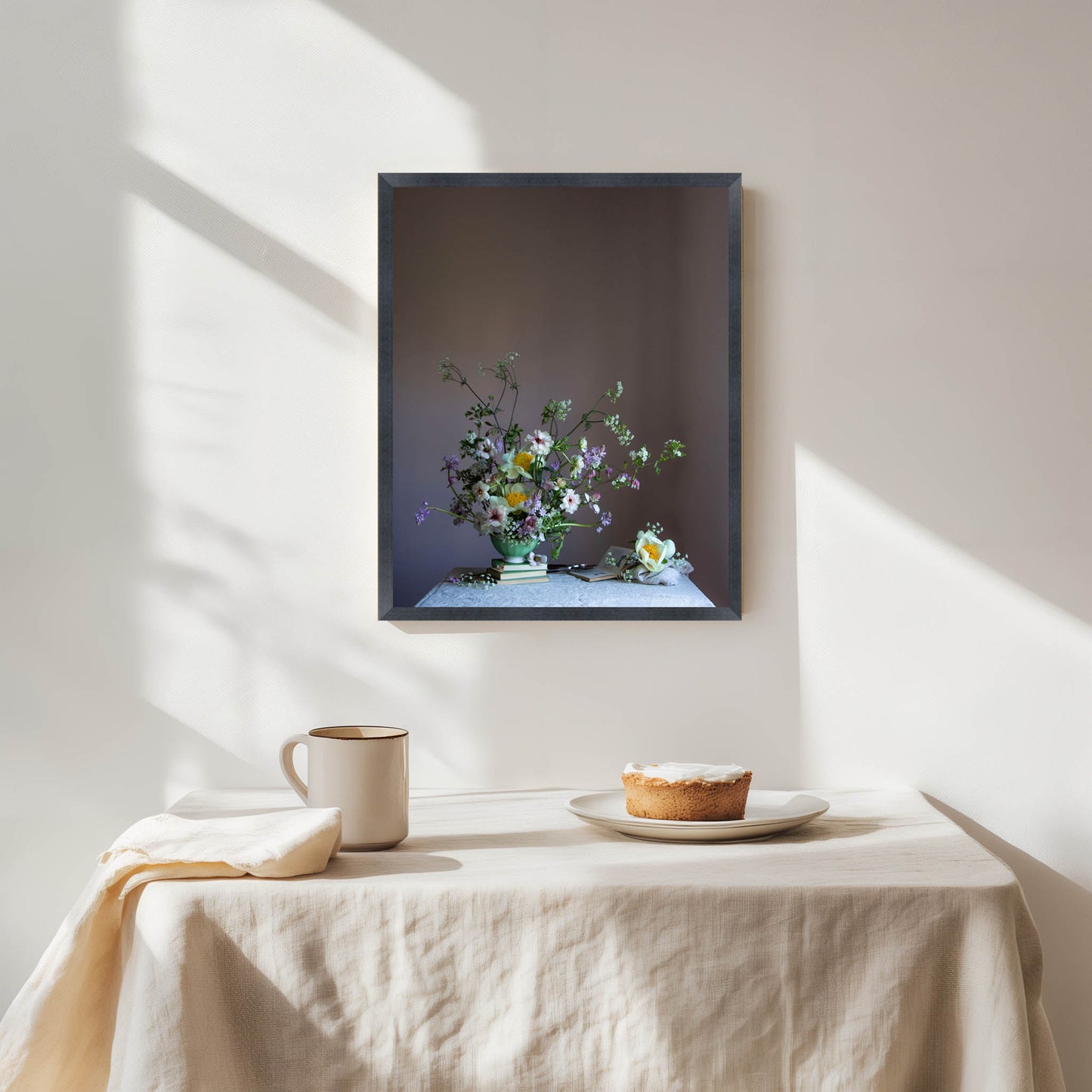Framed artwork of a still life with flowers on a tablecloth-covered table. Still life art