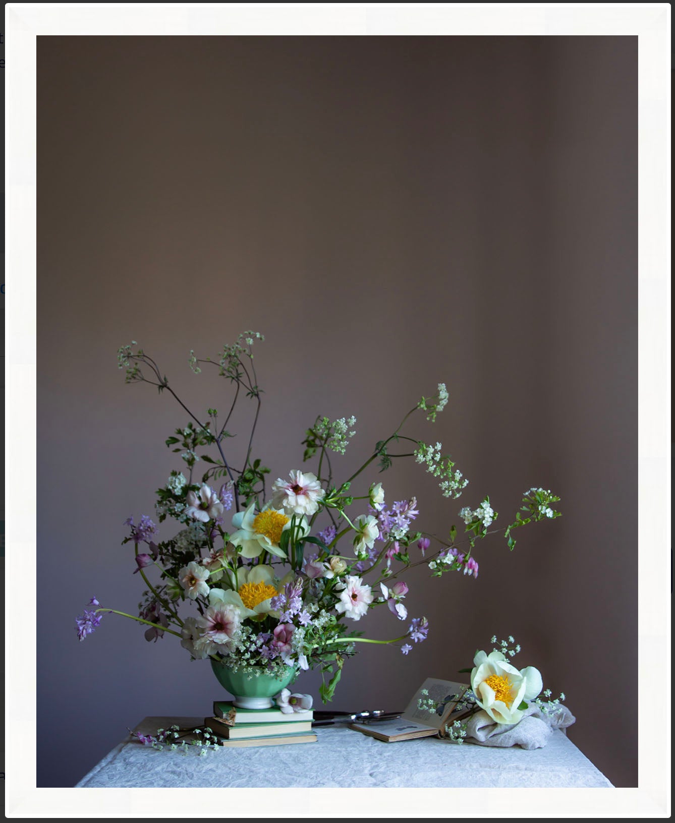 Floral arrangement in a green vase on a table with a plain background. Botanical print.