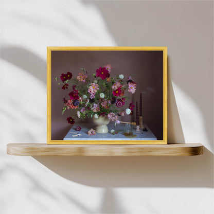 Framed artwork of a floral arrangement on a wooden shelf with a neutral background