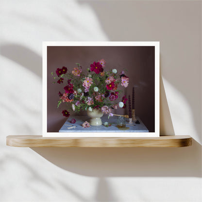 Framed photograph of a floral still-life on a wooden shelf with a neutral background