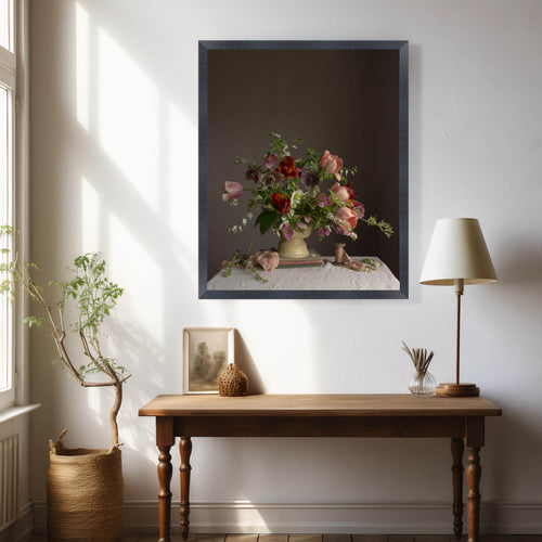 Room interior with a wooden table, lamp, and framed artwork on a white wall.  Floral photograph