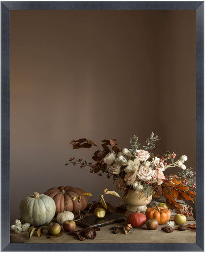framed Still life flower art with pumpkins, apples, and flowers on a wooden surface against a brown background.