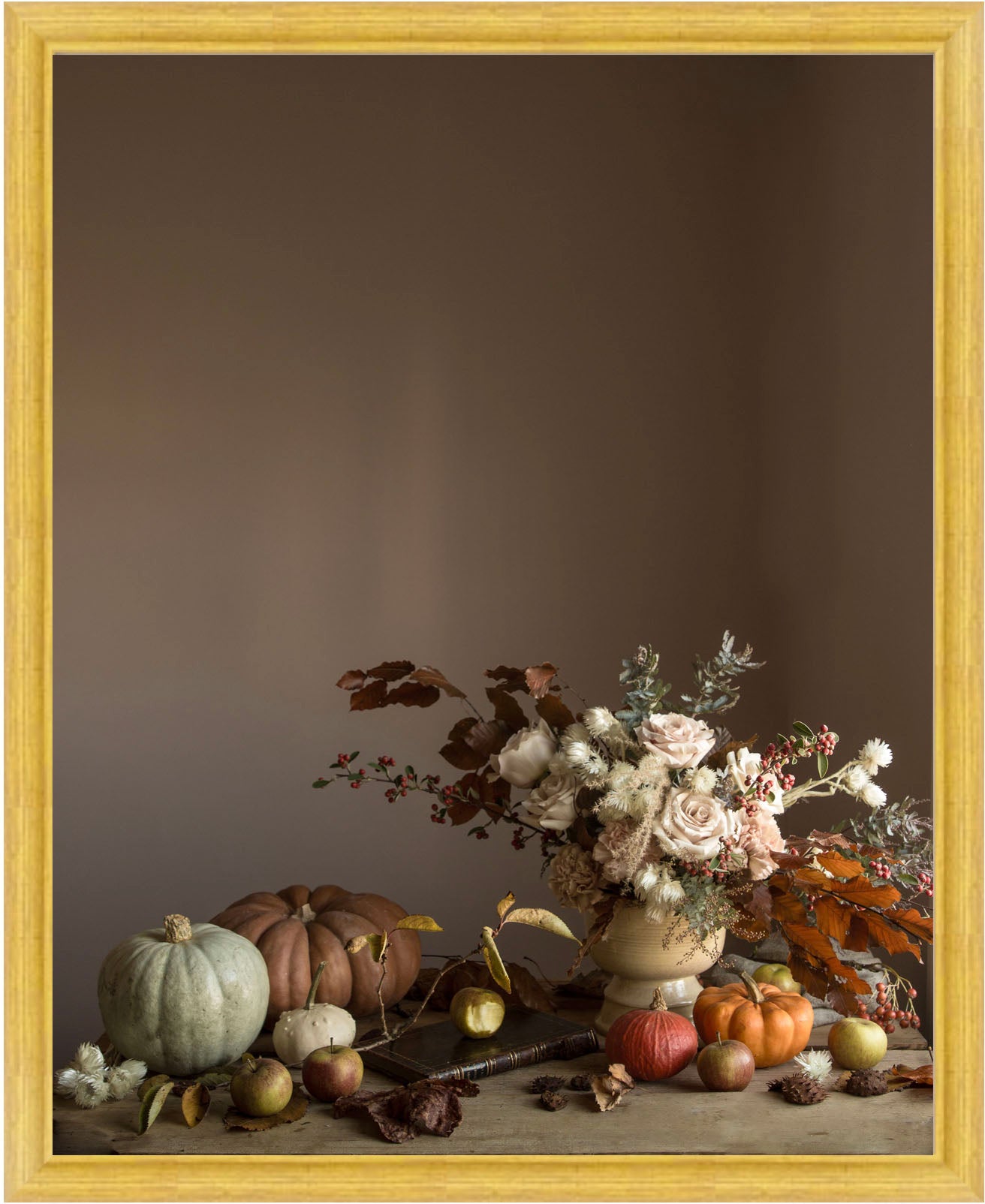 Framed Floral still-life with pumpkins and flowers on a wooden surface against a brown background.