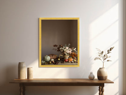 Framed artwork of a still life scene with flowers and fruits on a wall above a wooden table.
