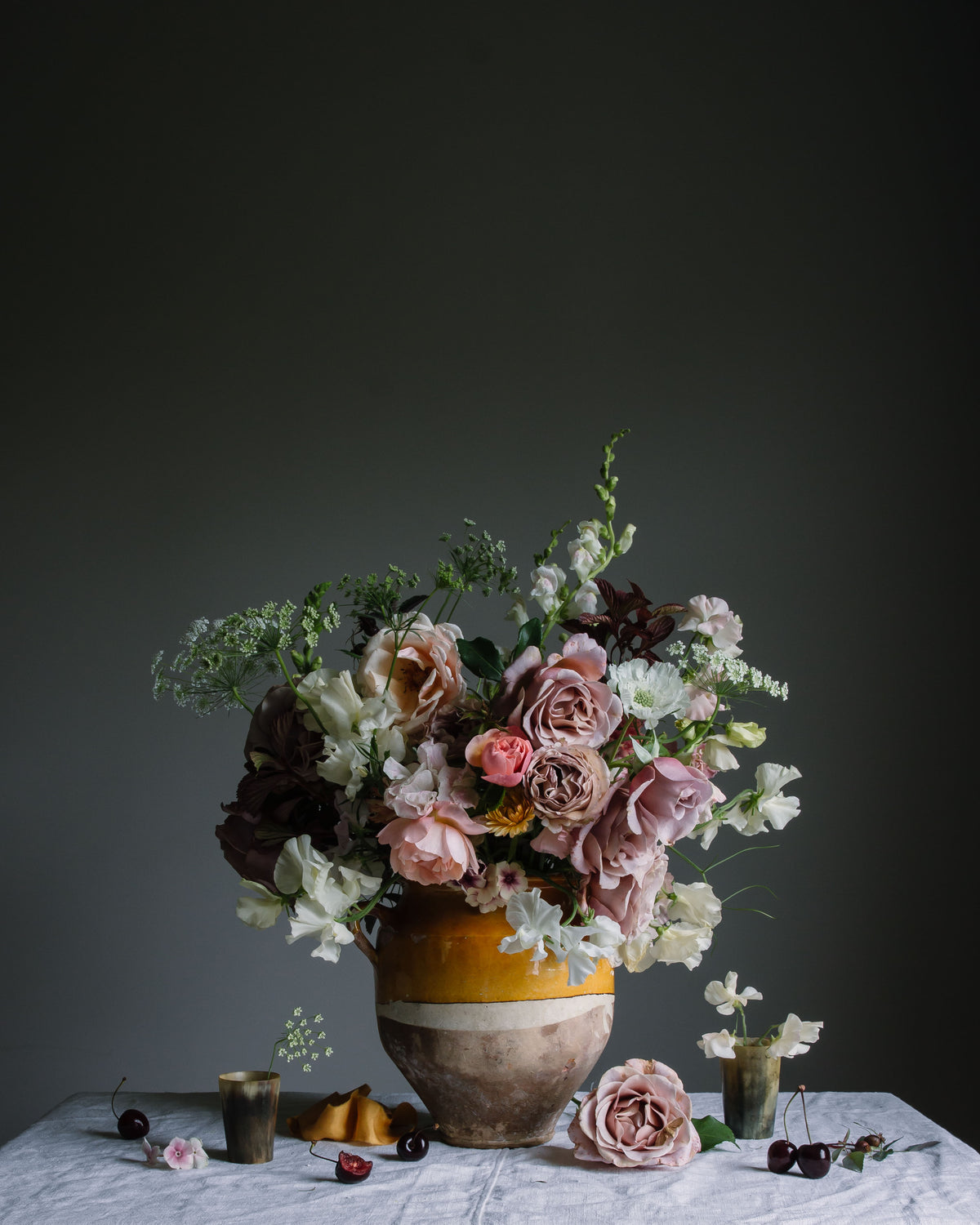 A botanical limited edition print of a flower arrangement featuring dusty pink roses, sweetpeas, and cherries by photographer Emma Harris.  Floral art
