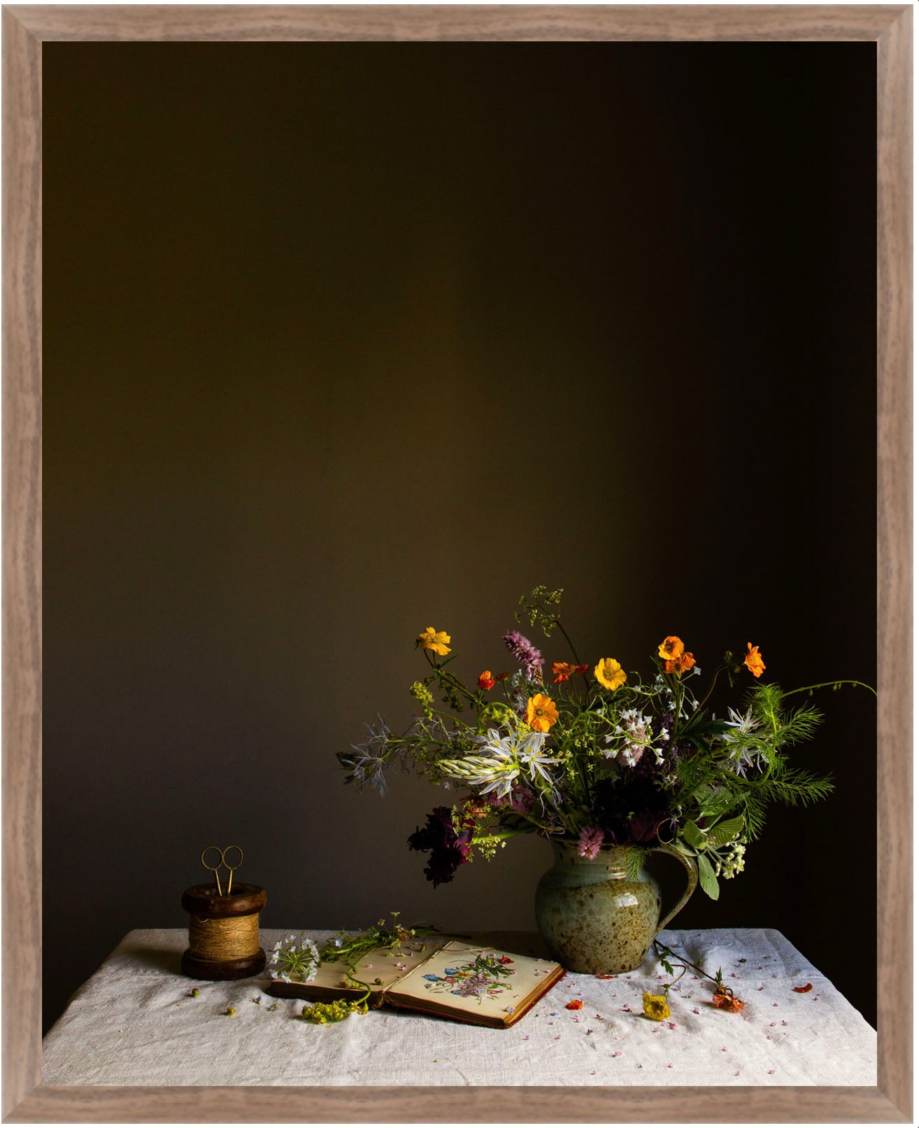Still life arrangement with flowers, a book, and a small pot on a textured surface against a dark background.   botanical print