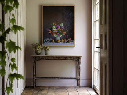 Room interior with a table, flowers, and a botanical artwork on the wall.