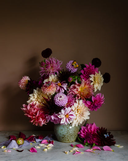 Floral still life of dahlias in a vase on a marble surface with butterflies by fine art photographer Emma Harris