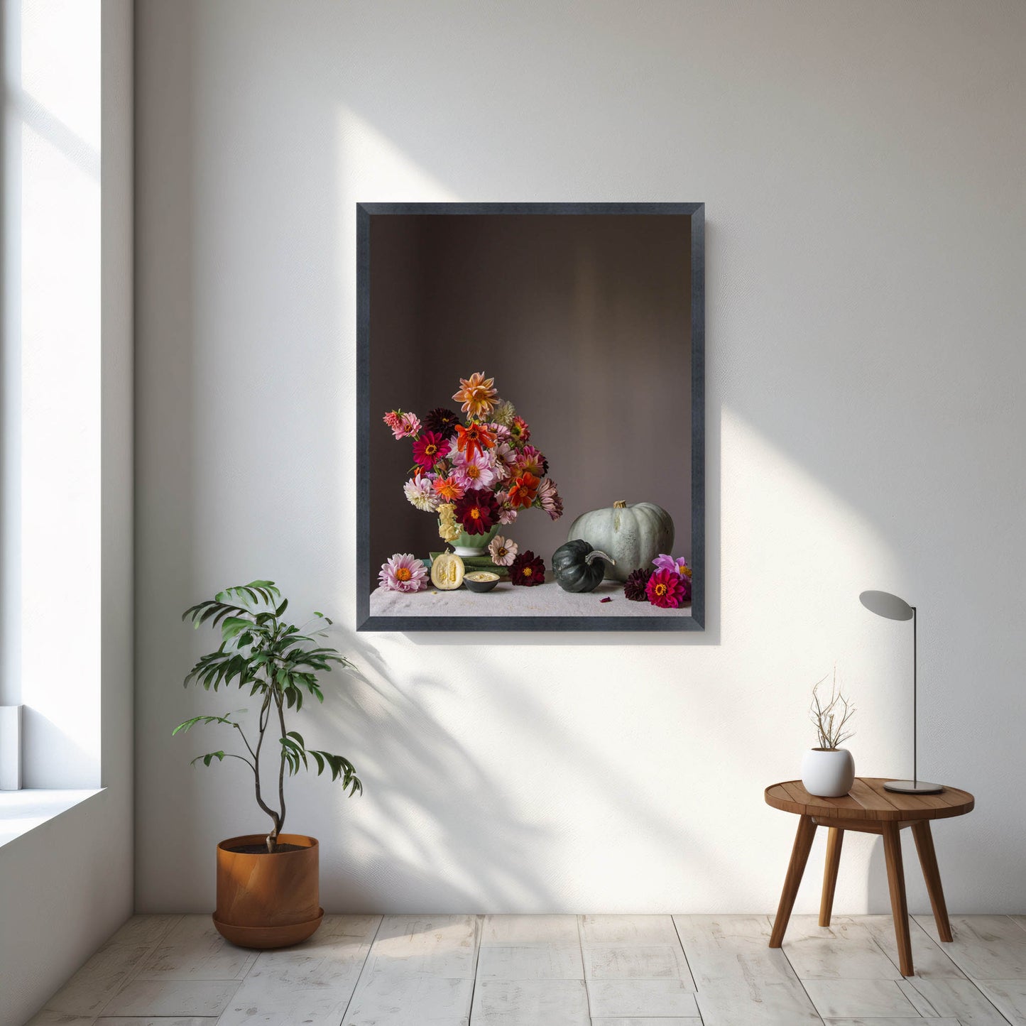 Framed floral artwork on a wall with a side table and plant in a room.   Flower print.