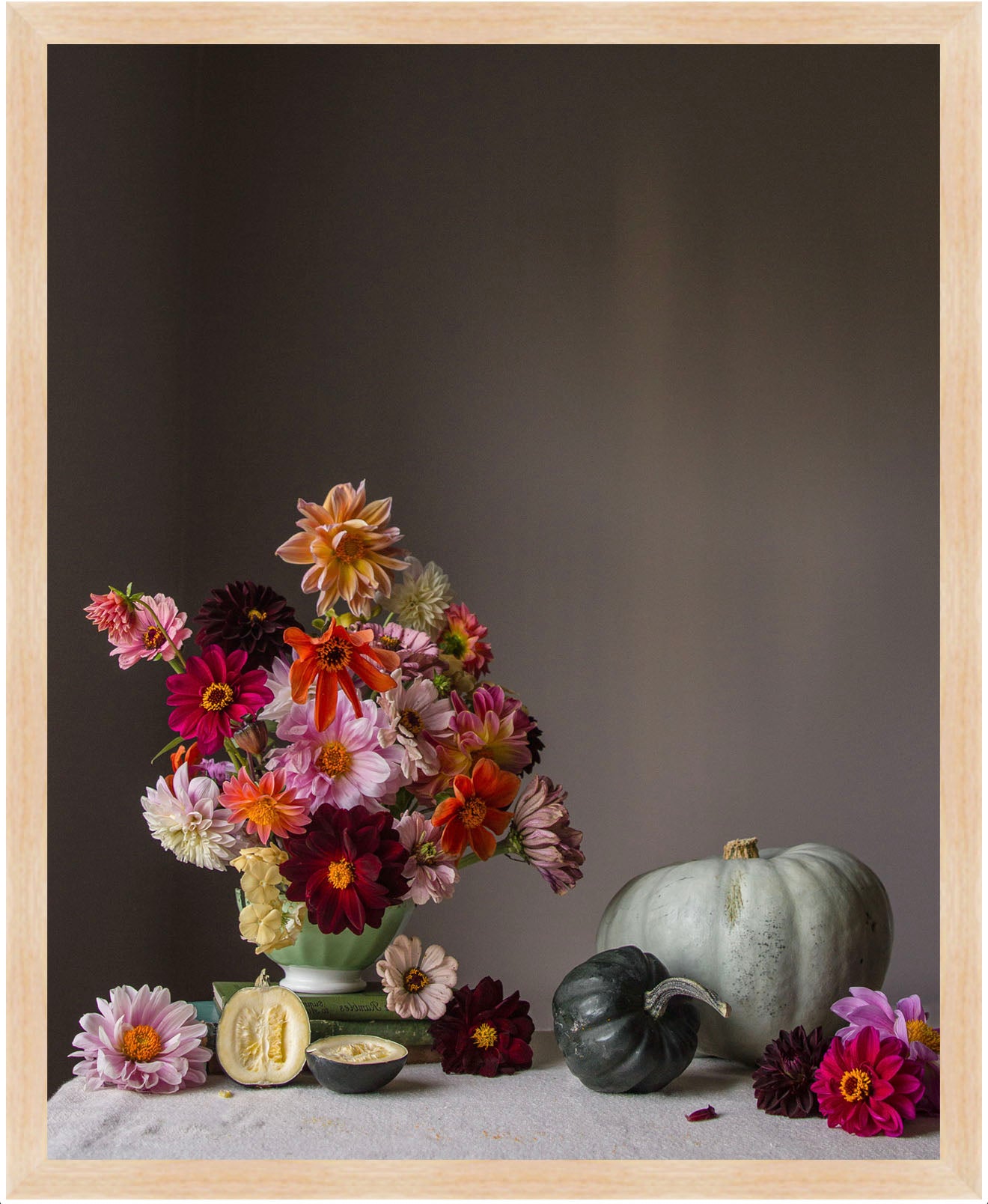Still life arrangement with flowers and pumpkins on a dark background.   Floral art.