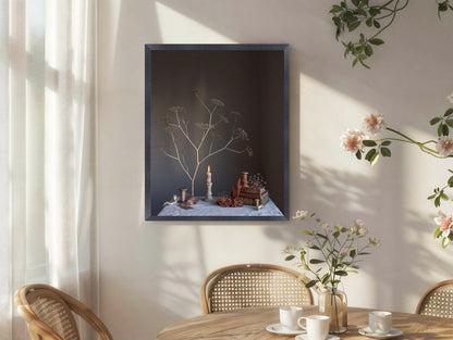 Framed artwork on a wall with a table and chairs in the foreground.   Botanical photograph.
