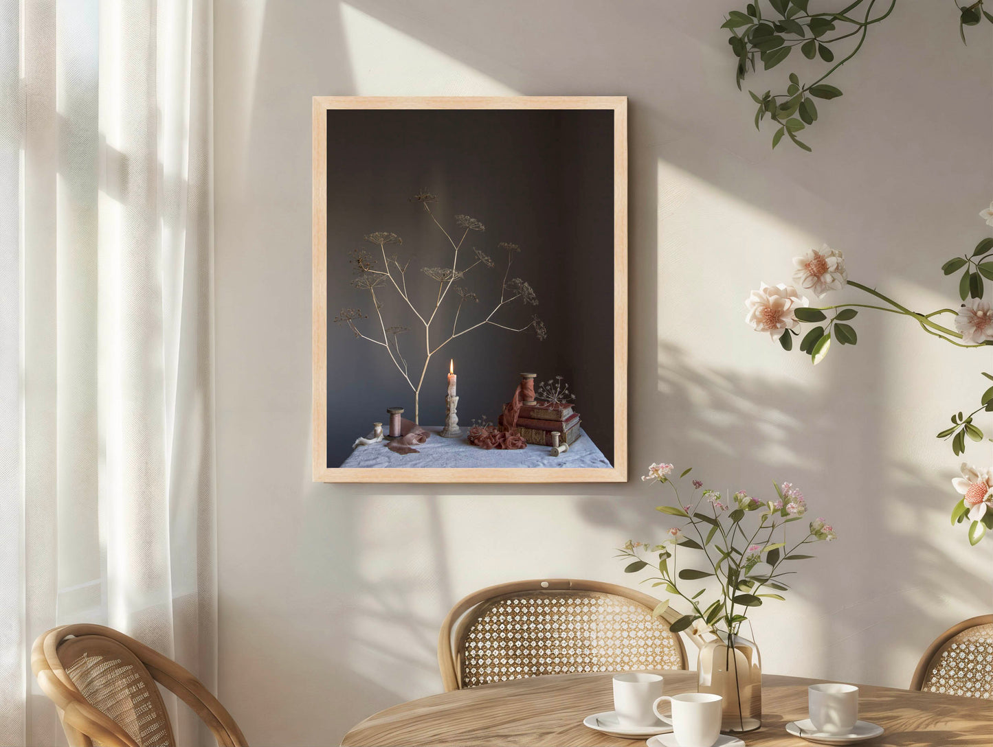 Framed artwork on a wall with a table and chairs below.   Floral art.