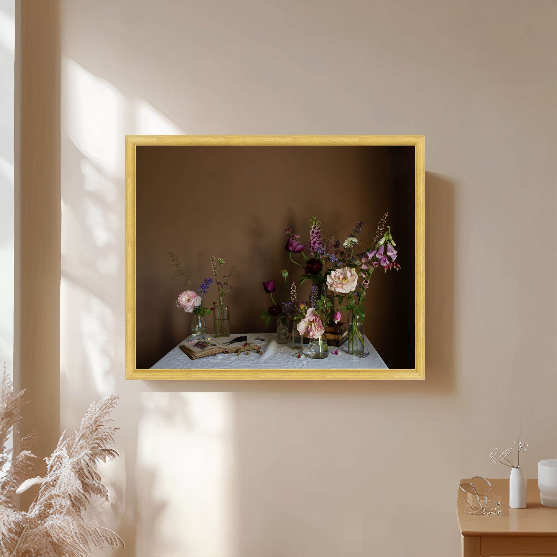 Framed artwork of flowers on a table against a brown background