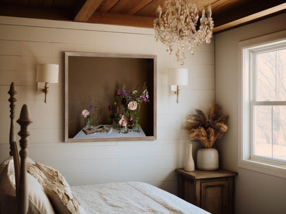 Bedroom with wooden bed, framed still-life floral print, and decorative elements.