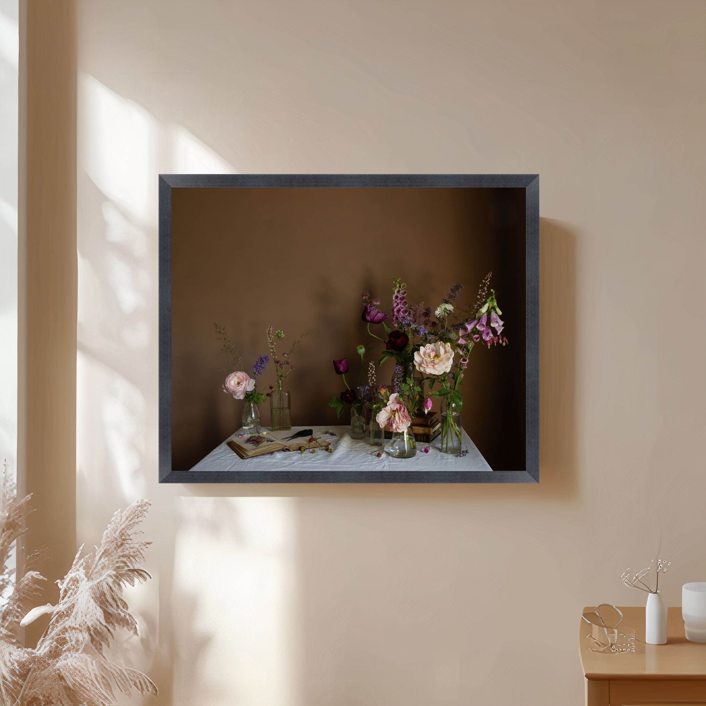 Framed photograph of flowers on a table against a beige wall