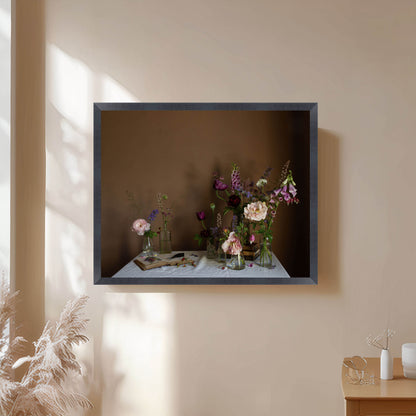 Framed photograph of flowers on a table against a beige wall