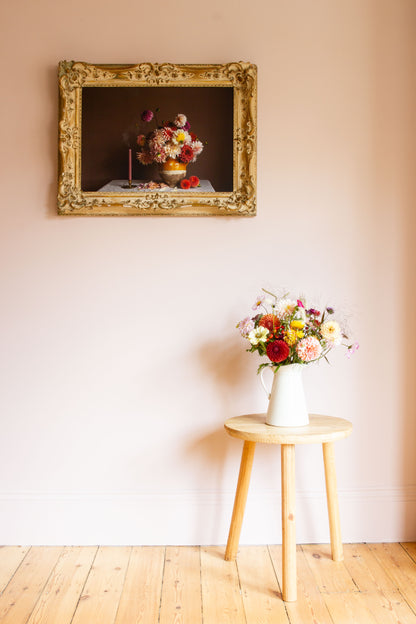 Large framed floral still-life of dahlias by photographer Emma Harris in a calm room with flowers on a table