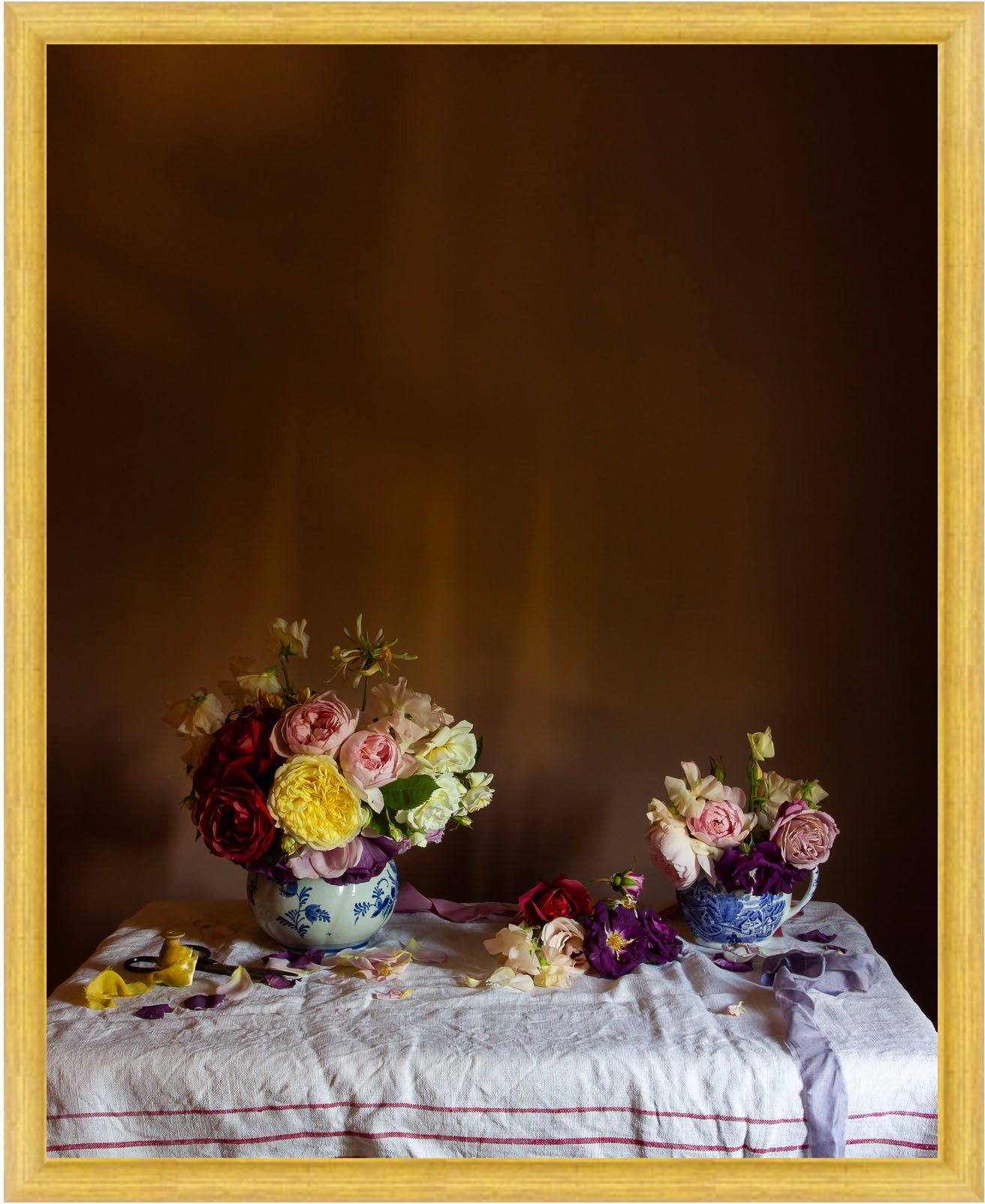 Framed limited edition photograph of two floral arrangements on a tablecloth with a dark background