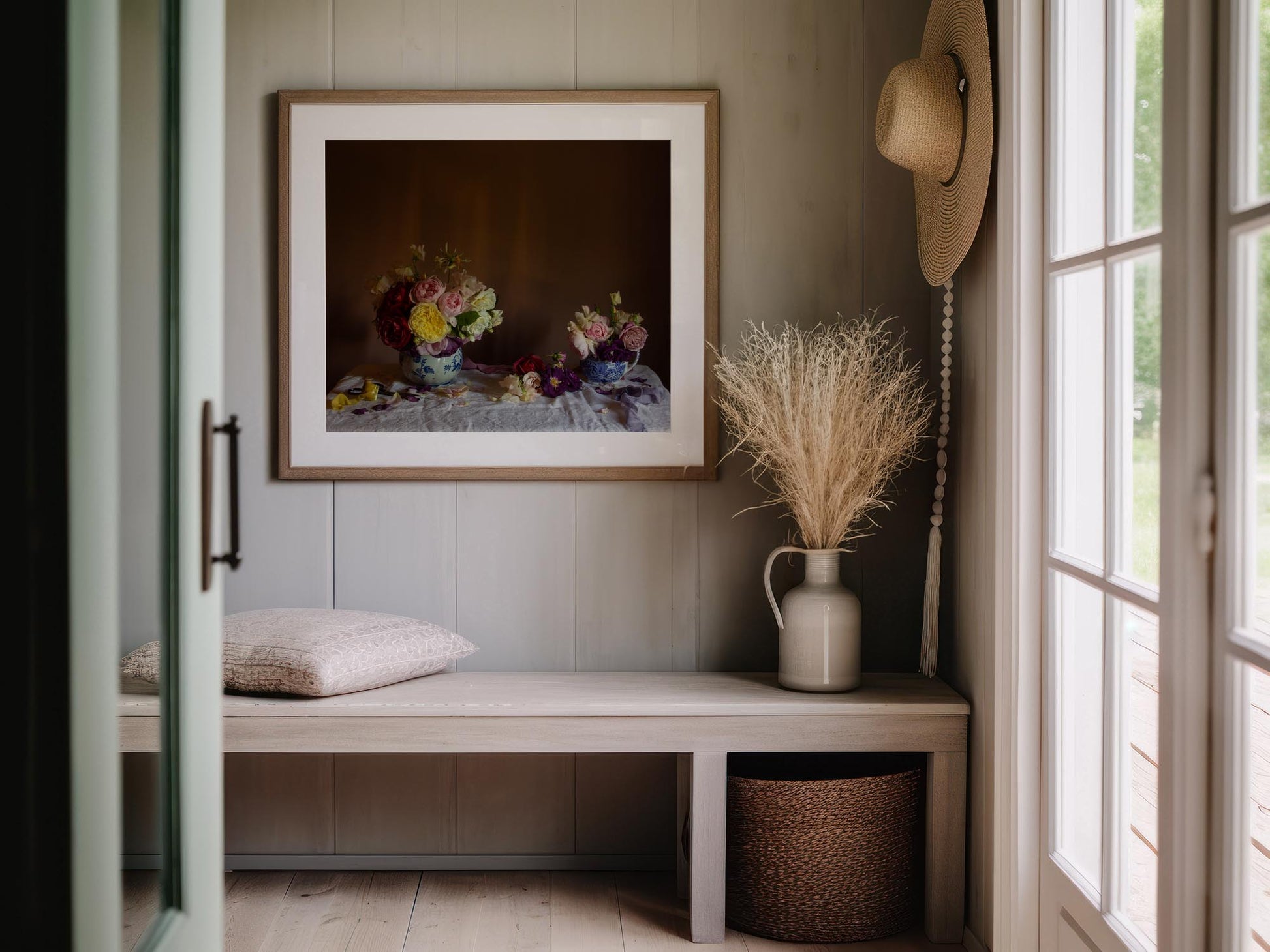 Floral still-life art of roses in a walnut frame in an entrance way.