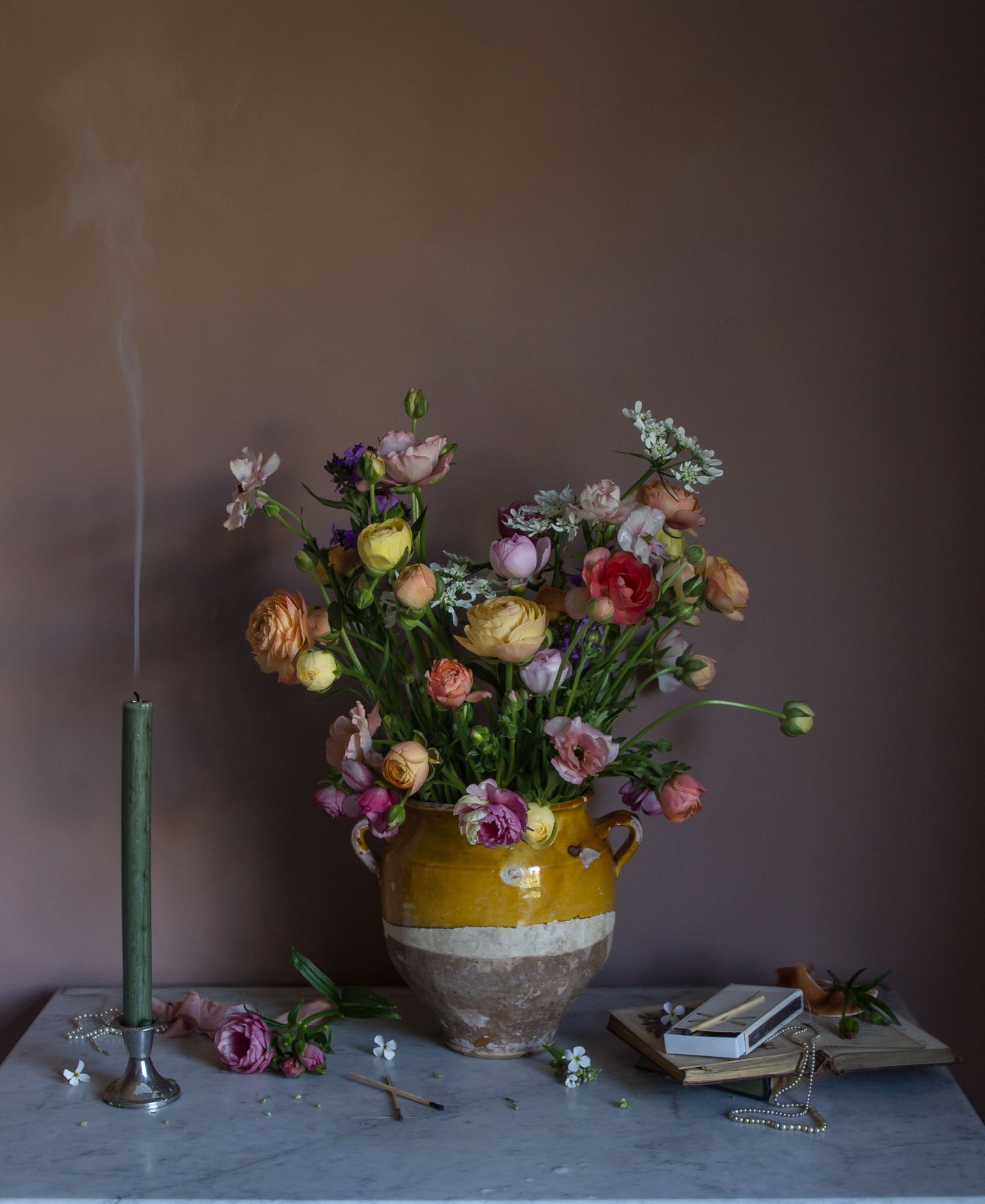 Floral still life print of ranunculus and a smoking candle on a marble surface