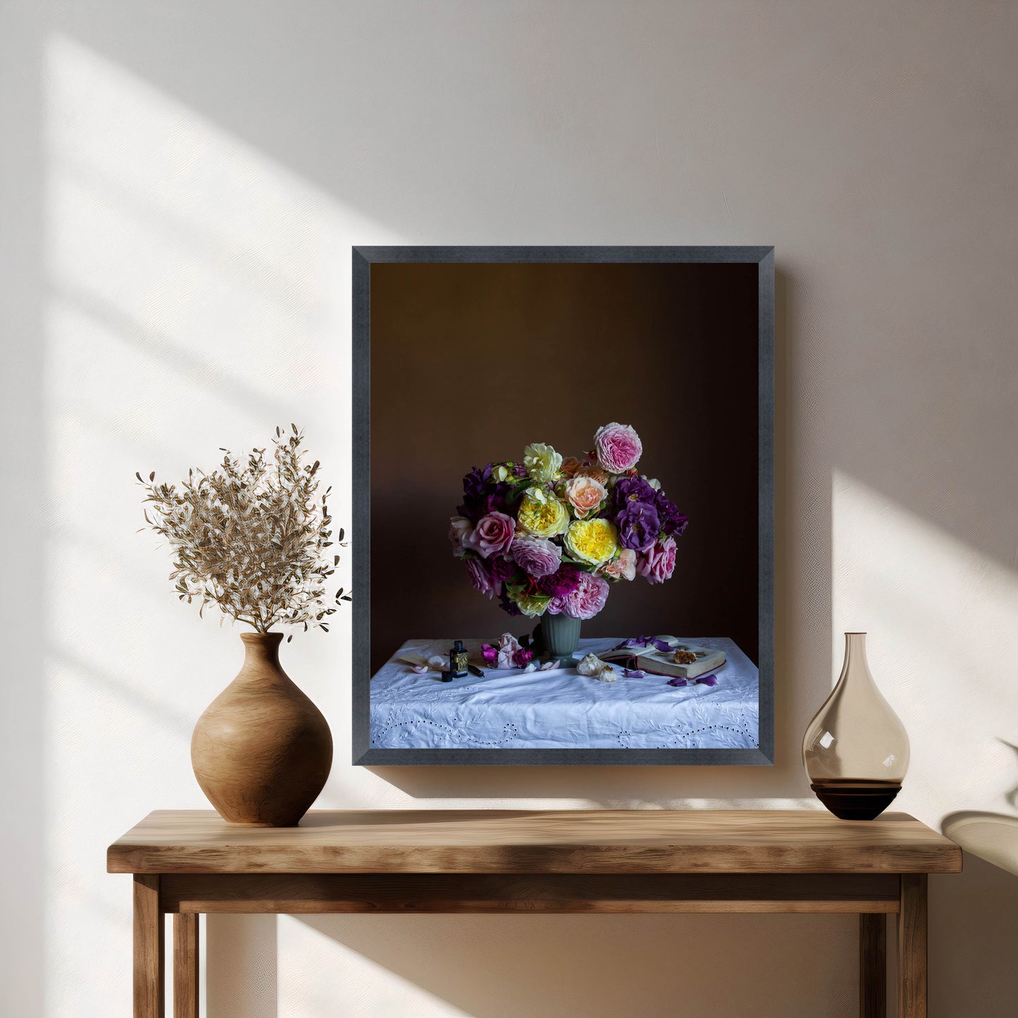 Framed artwork of a floral arrangement on a wooden table with decorative vases.
