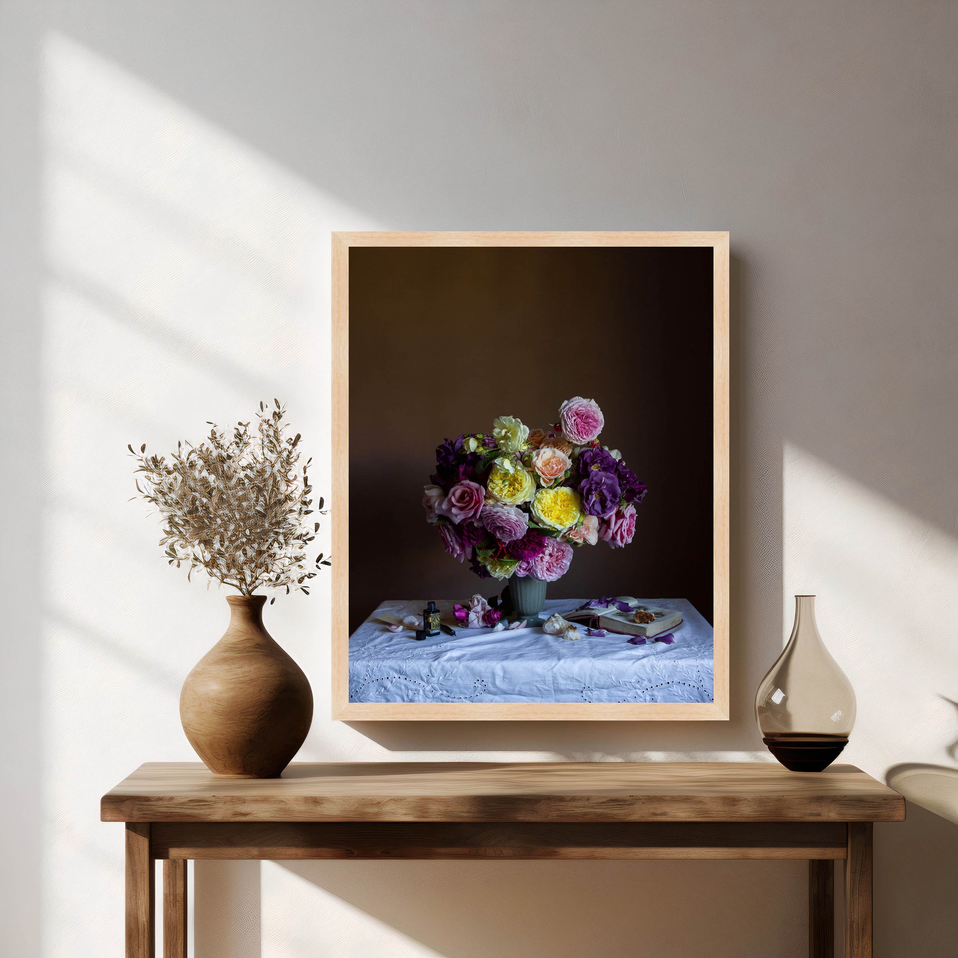 Framed artwork of a floral arrangement on a wooden table with decorative vases.