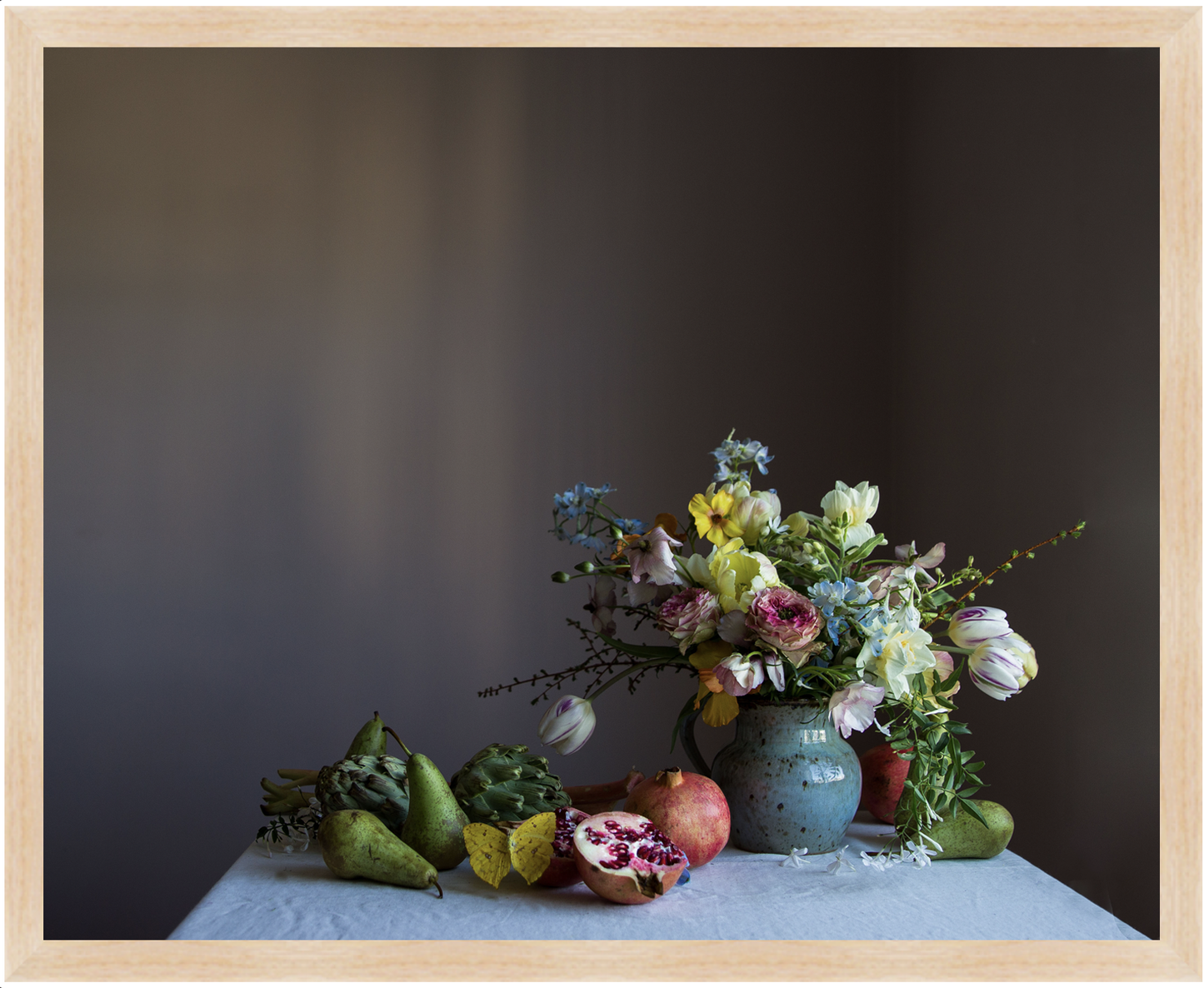 Still life arrangement with flowers, pears, and a fruit on a dark background. Flower art