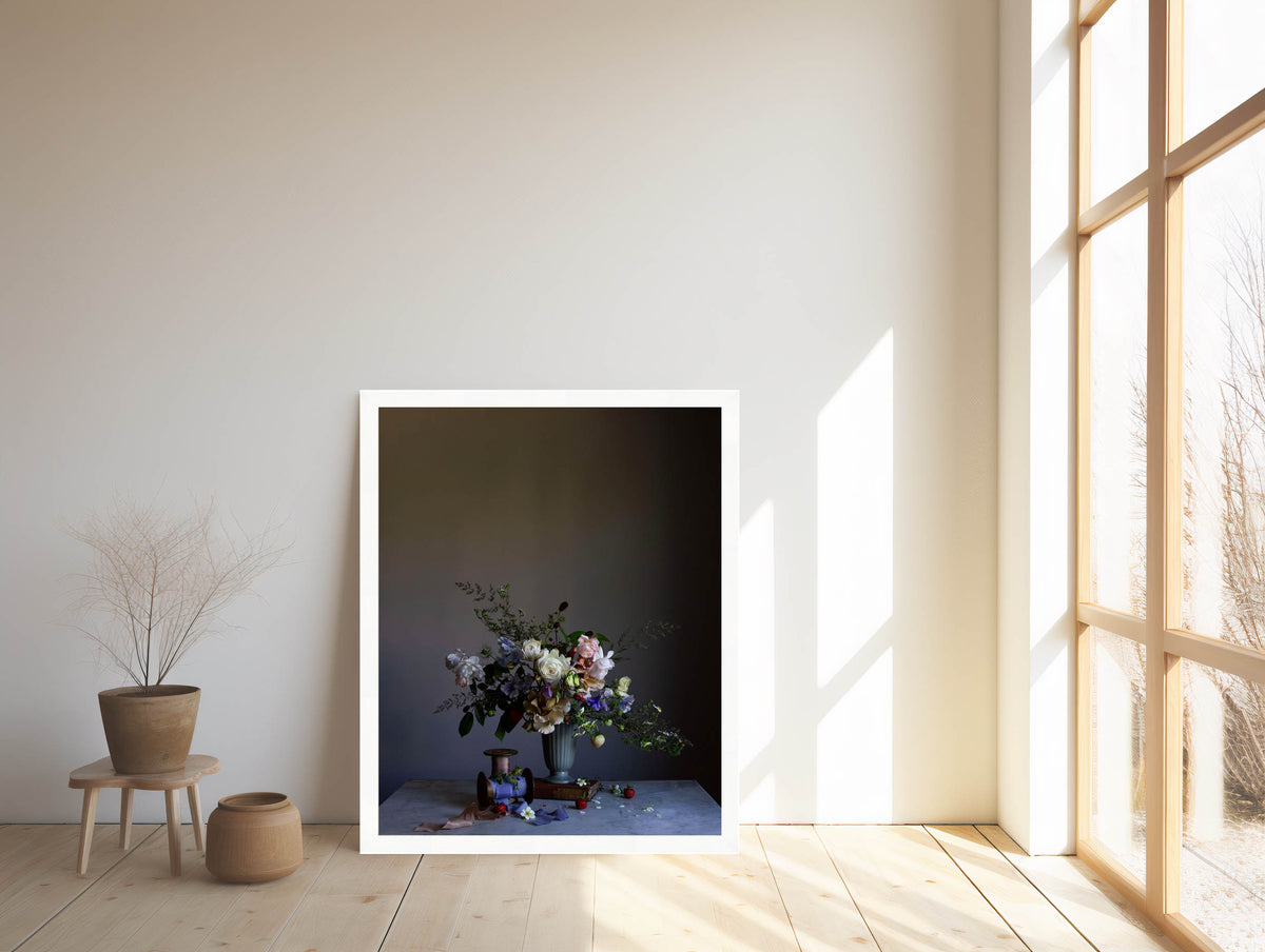 Framed artwork of a still life scene with flowers on a table in a room with large windows.   Flower artwork