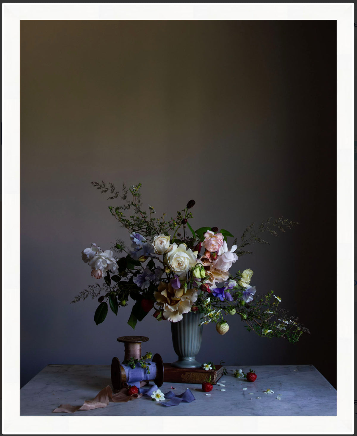Floral arrangement in a vase on a table against a dark background.   floral print