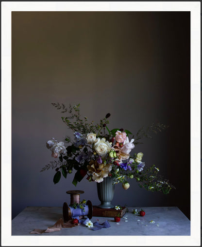 Floral arrangement in a vase on a table against a dark background.   floral print