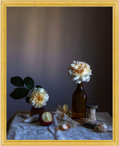 Framed Still life arrangement with roses in bottles on a textured surface, framed in gold. Botanical art