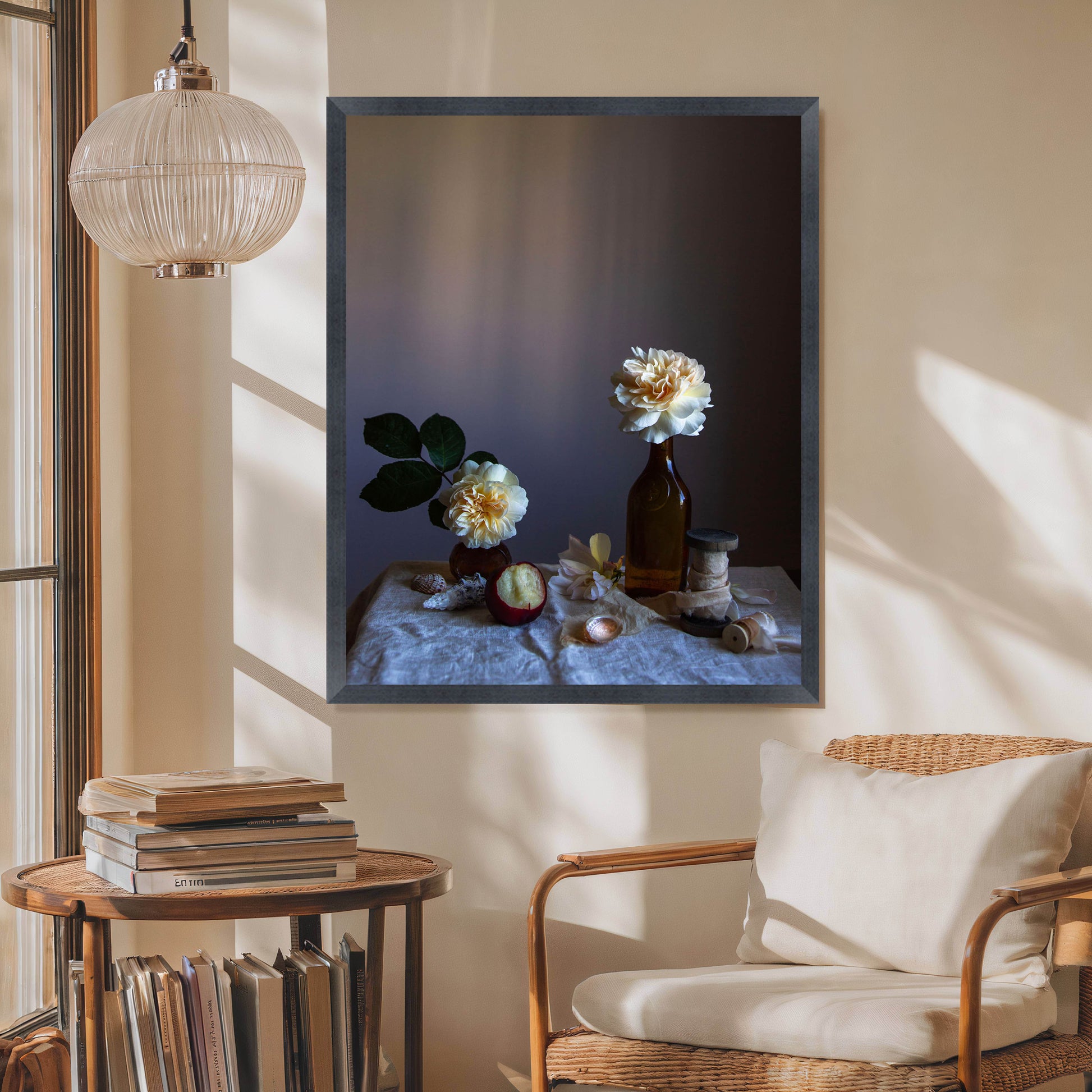 Framed artwork of a still life scene on a wall above a chair and side table.  Botanical picture.