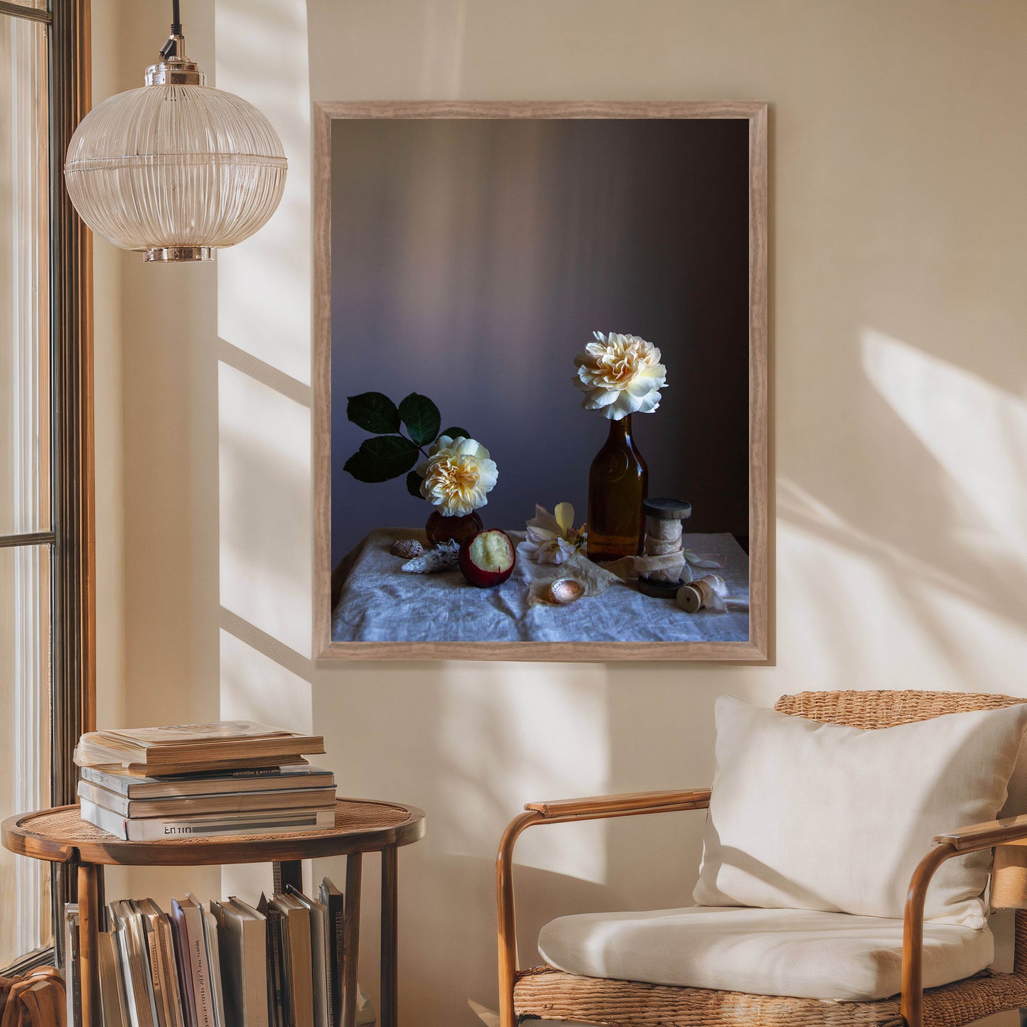 Framed still-life artwork on a wall with a chair and small table below.  