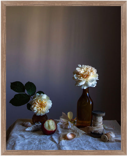 Framed still life arrangement with flowers in bottles on a textured surface against a dark background. Floral picture.