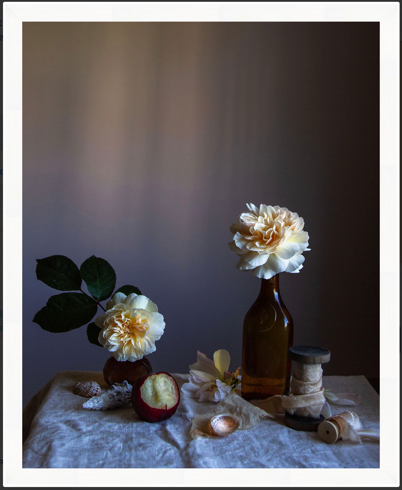 Framed still life arrangement with flowers in bottles on a textured surface. Flower picture