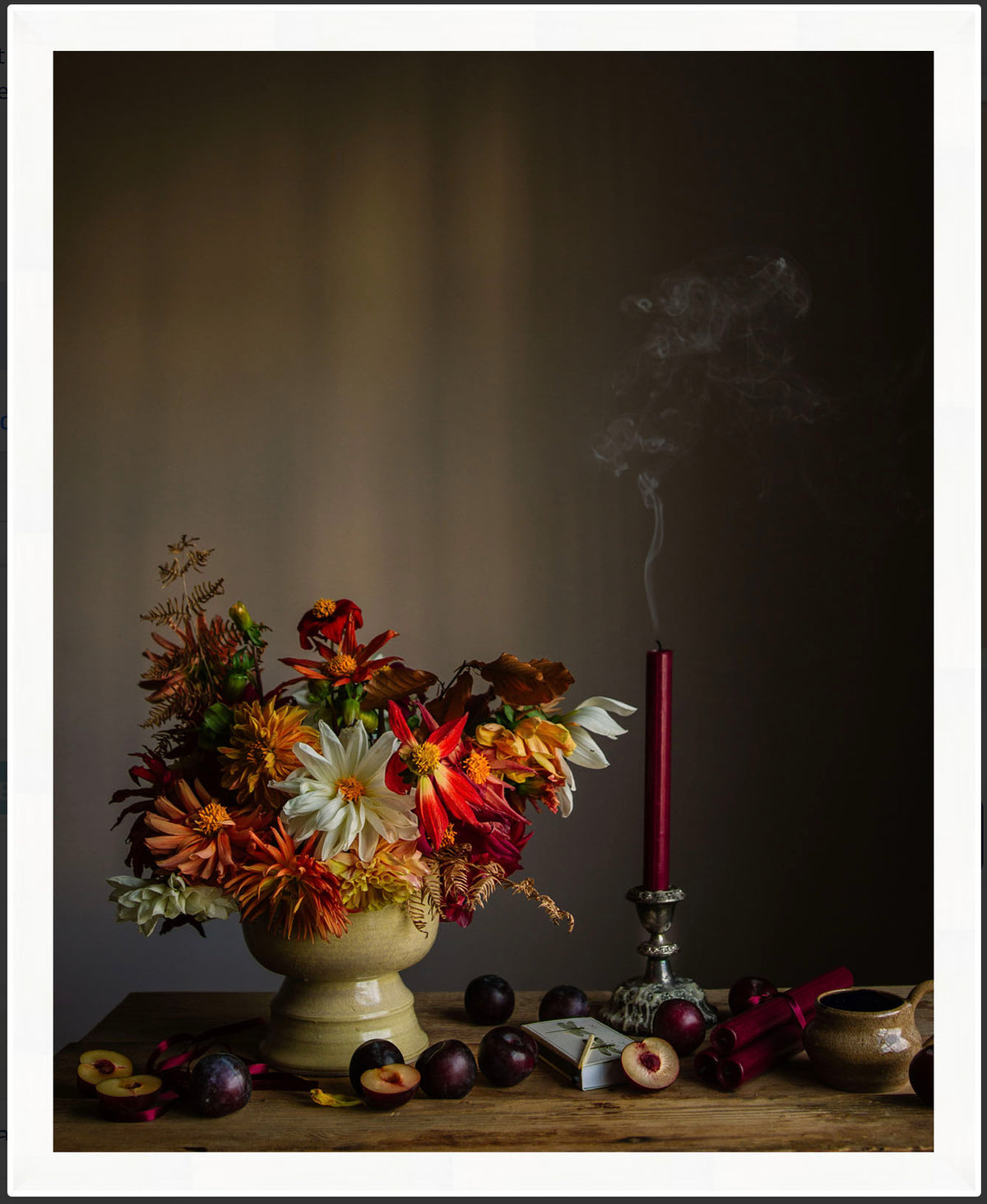 Framed botanical photograph of dahlias and smoking candle