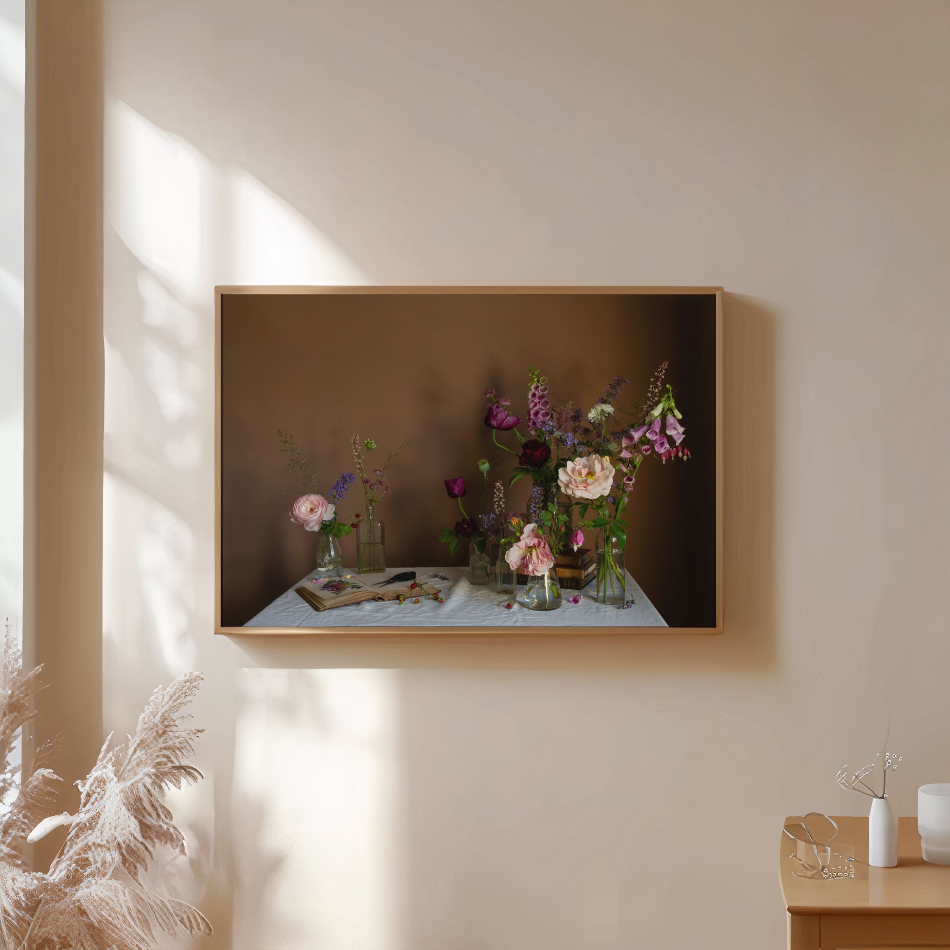 Framed artwork of foxgloves and roses by Emma Harris on a wall with soft lighting