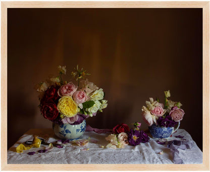 Framed floral still-life art showing Two floral arrangements in jugs on a textured surface with a dark background in an oak frame