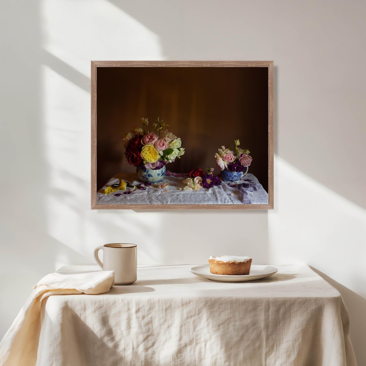 Framed still life artwork of flowers in a walnut frame in a dining room