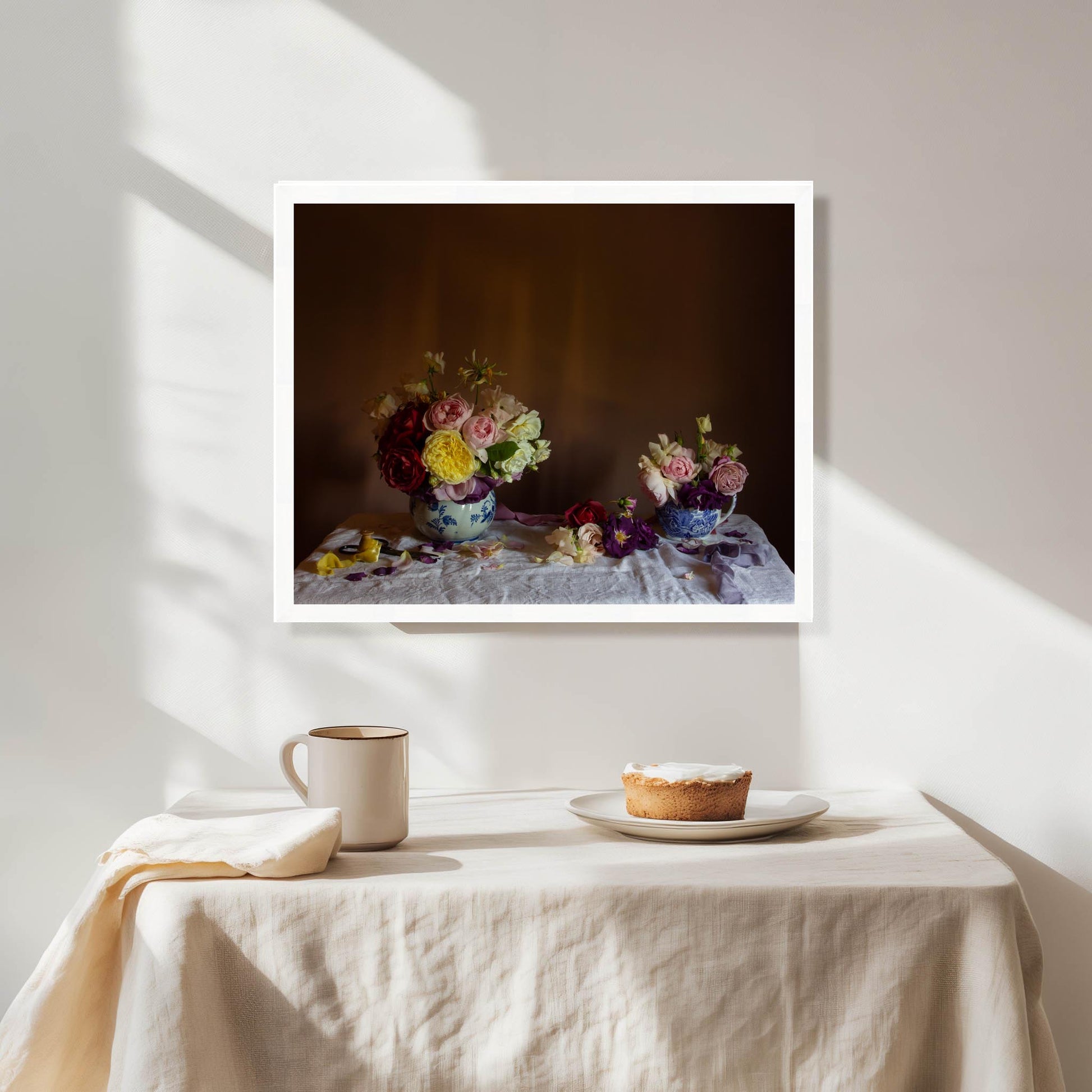 Framed artwork of floral still-life in a white frame in a dining room